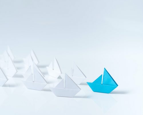 Leadership conceptual using blue paper ship